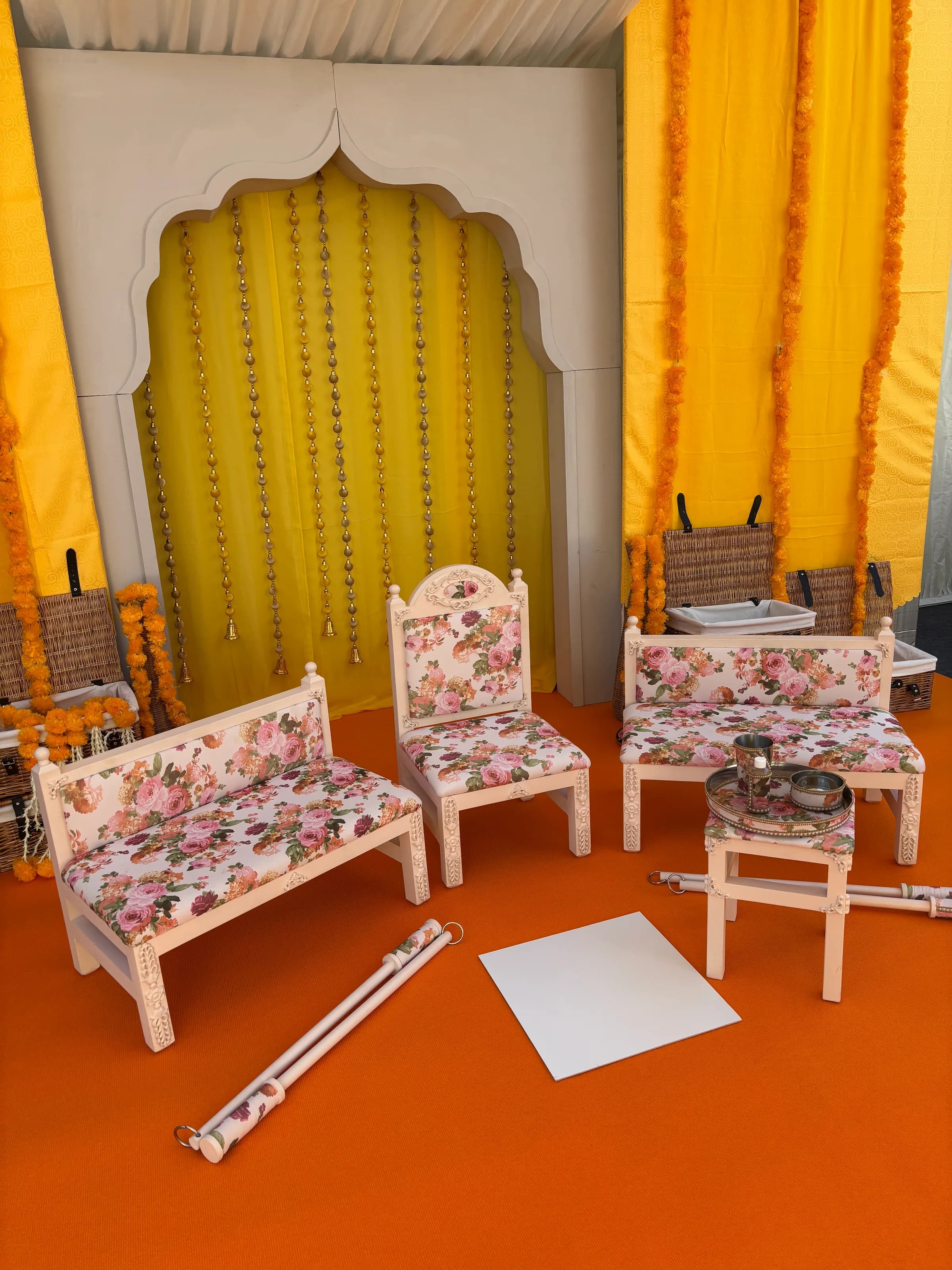 The Enchantress suite set against yellow drapes and marigold strings on an orange floor covering for a Maiyan ceremony.
