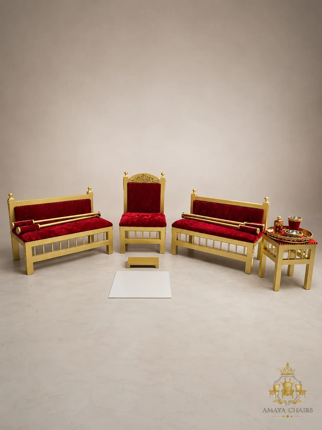 The Royal Crimson Maiyan suite on an ivory backdrop: gold frames with a carved crest and deep red crushed velvet seats, with matching tray table and brass Sagan tray.