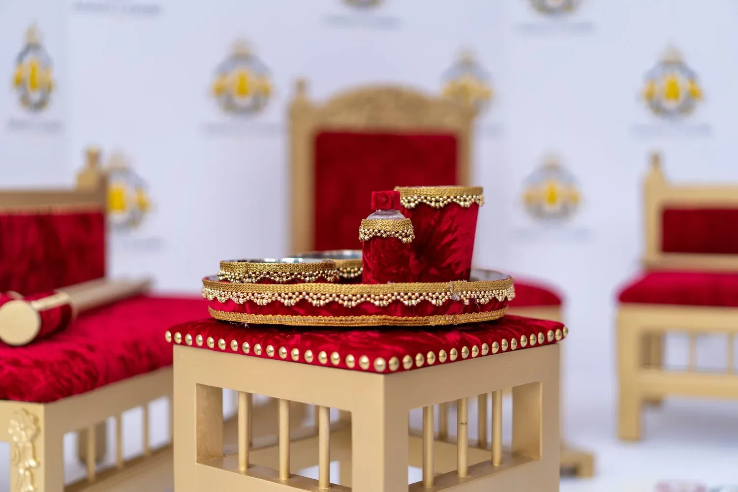 The Royal Crimson tray table dressed with the brass Sagan tray, set between the gold-framed benches.