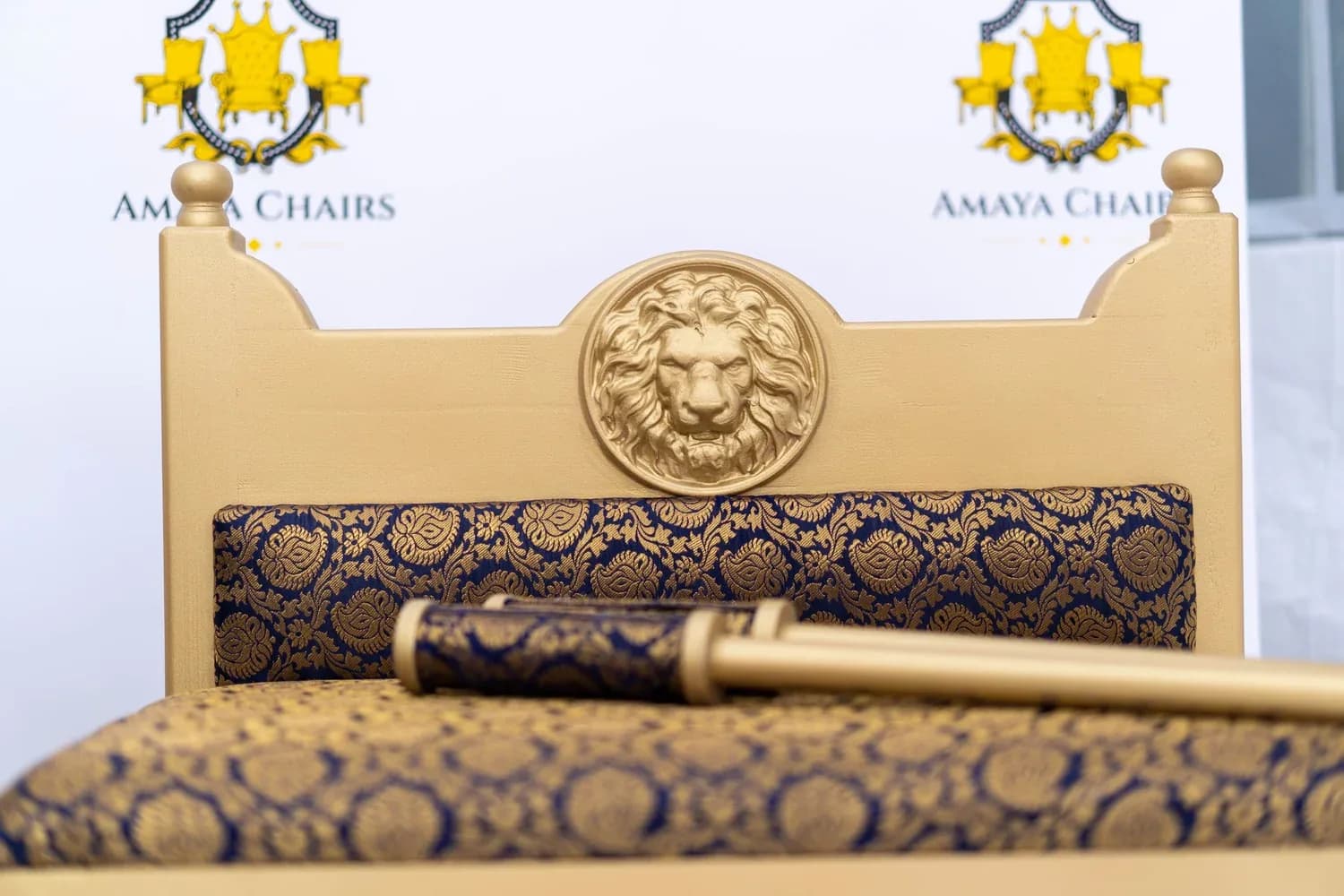 The Majestic Lion head chair seen from the front, showing the sculpted lion medallion above the dark brocade upholstery.